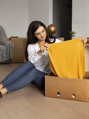 Full shot of a woman packing items into a box